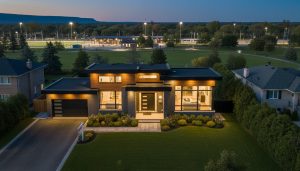 Twilight professional photo of a Milton Ontario home with warm interior lights and drone view of nearby park and GO station.