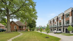 Older brick bungalow and modern townhouses in Milton, Ontario showing difference in home age and style