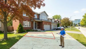 Milton house with survey map overlay showing easement and surveyor reviewing plans