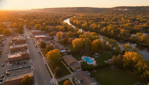 Aerial drone view of a Georgetown, Ontario home with backyard pool, Credit River nearby, and Escarpment in the distance at golden hour.