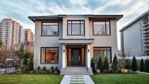 Modern house with large windows and lush garden.