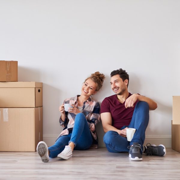 happy-couple-with-coffee-cups-relaxing-their-new-home