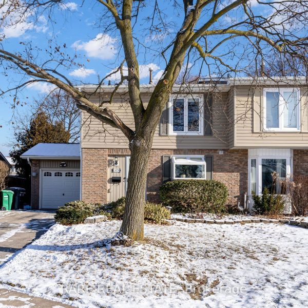 Suburban house in winter with snow-covered lawn.