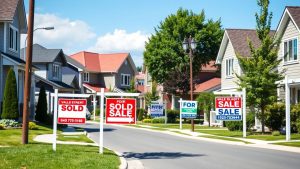 Residential street with multiple for sale signs.