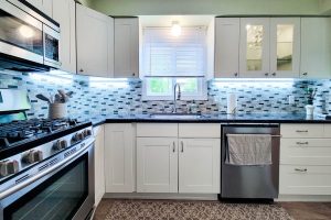 Modern kitchen with white cabinets and stainless appliances.