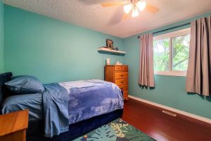 Cozy bedroom with blue walls and single bed.