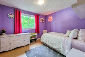 Cozy purple bedroom with bed and dresser