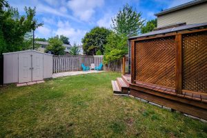 Backyard with shed and patio seating area.