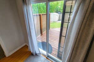 Sliding door opens to wooden deck and yard.