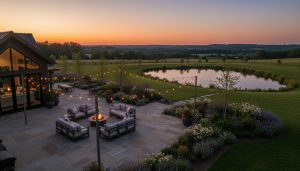 Twilight view of a luxury rural property with patio, firepit, string lights and rolling hills