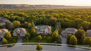 Aerial drone photo of a suburban Milton, Ontario home near conservation areas showing the house, yard and neighborhood from above at golden hour.