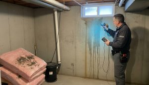 Home inspector using moisture meter and infrared camera detecting hidden water damage in a Milton, Ontario basement