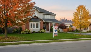 Suburban Milton house with a professional 'For Sale' lawn sign featuring a QR code in front yard