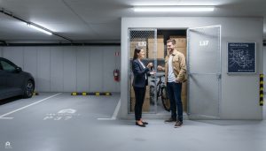 Milton condo underground parking stall and storage locker with real estate agent handing keys to buyers