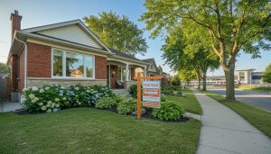 Detached house in Georgetown, Ontario with a 'For Sale By Owner' sign on the lawn and GO station visible in the distance.