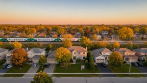 Aerial view of Georgetown, Ontario neighbourhood with a For Sale sign and commuter train in the distance.