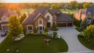 Exterior of a well-staged estate home in Georgetown, Ontario with For Sale sign at golden hour.