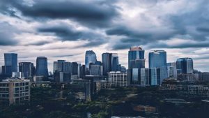 Skyscrapers under cloudy sky in urban skyline.