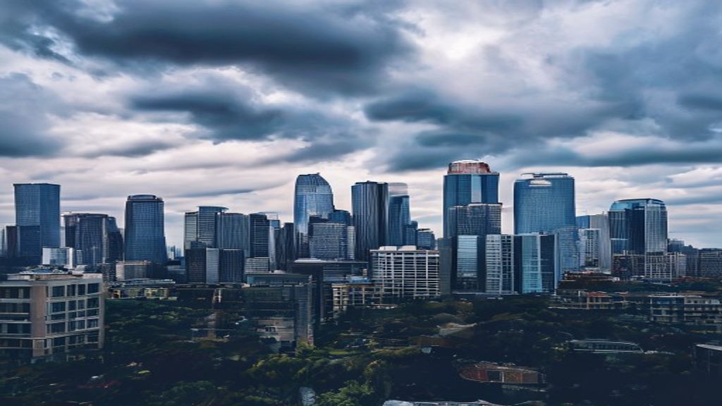 Skyscrapers under cloudy sky in urban skyline.